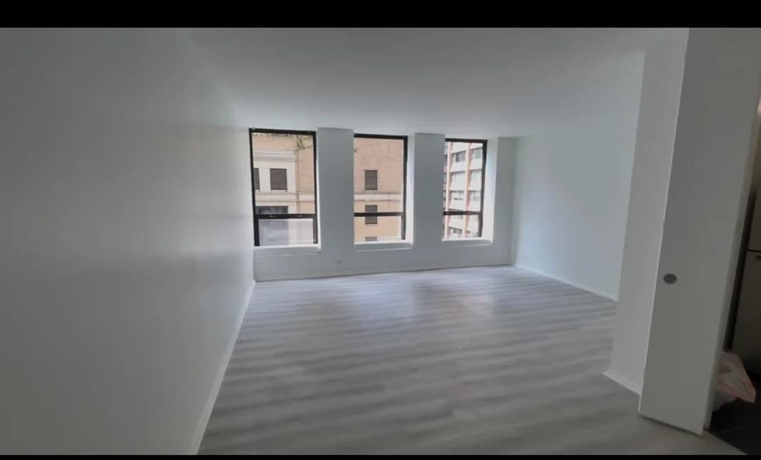 Empty living room before the redesign, with bare walls and no furniture