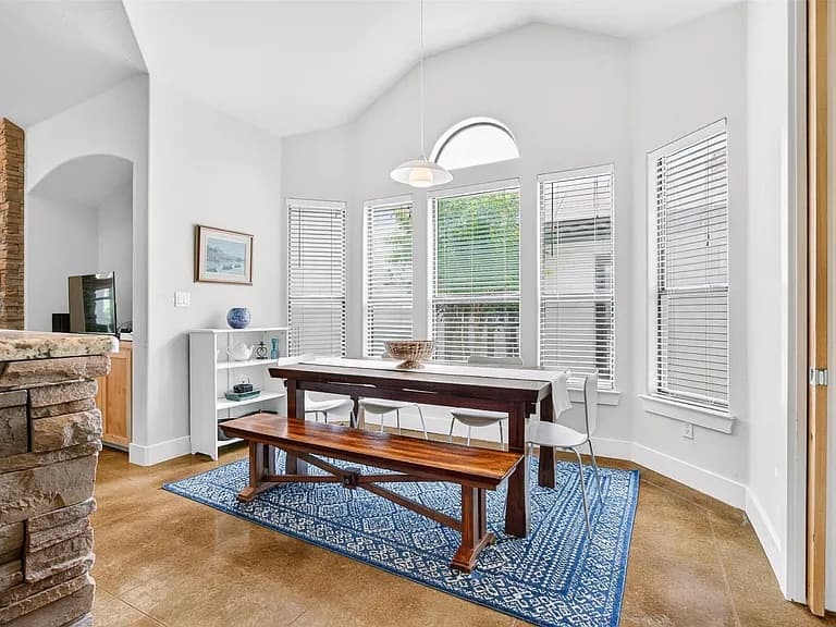 A minimalist dining room with white walls, a single window, and no furniture.