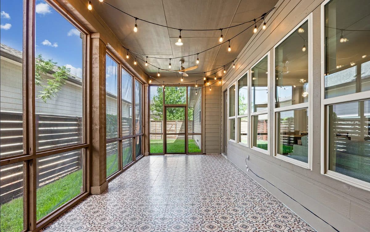 A bland, empty outdoor patio with concrete flooring and a plain brick wall. There are no furniture pieces or decorations, leaving the space uninviting and devoid of personality.